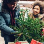 PAREJA BAJANDO ARBOL DE NAVIDAD Y REGALOS PARA LA FAMILIAS, LLENOS DE FELICIDAD Y BUSCANDO CREAR MOMENTOS FELICES Y MEMORABLES.