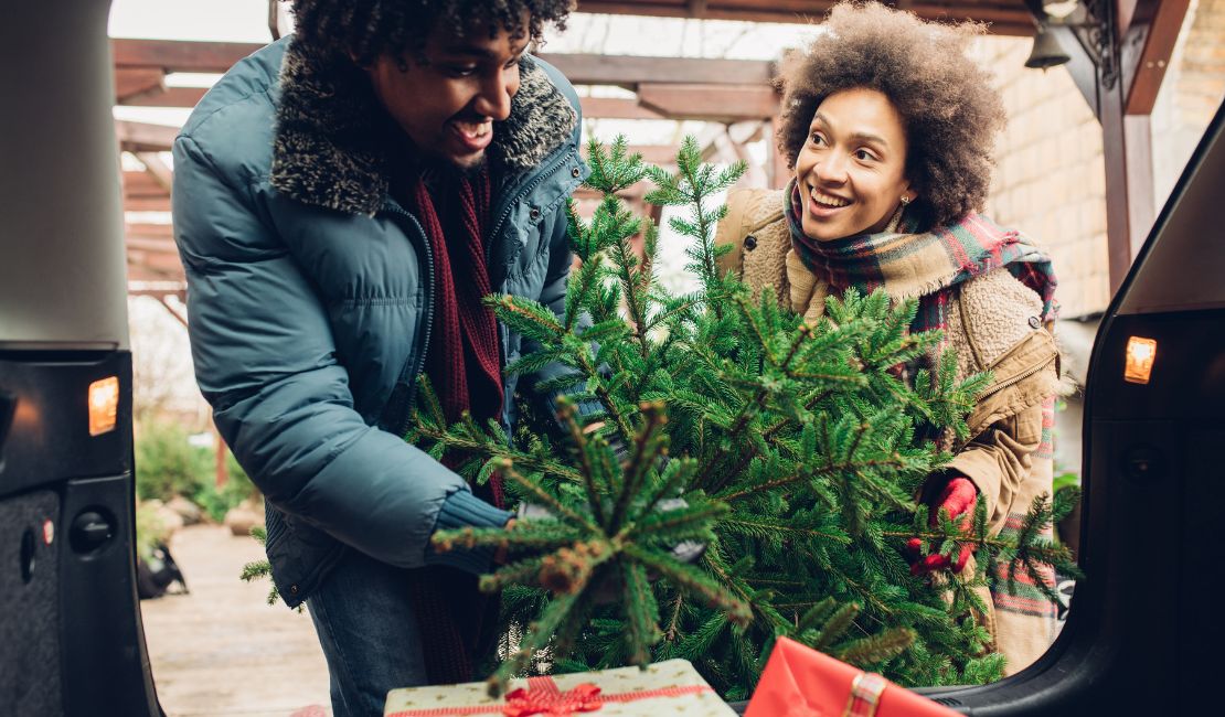 PAREJA BAJANDO ARBOL DE NAVIDAD Y REGALOS PARA LA FAMILIAS, LLENOS DE FELICIDAD Y BUSCANDO CREAR MOMENTOS FELICES Y MEMORABLES.